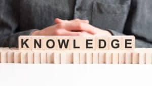 hand-puts-wooden-cube-with-letter-knowledge