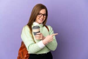 teenager-student-girl-isolated-purple-surface-pointing-finger-side